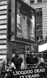 Military recruiting video above demonstrators with banner